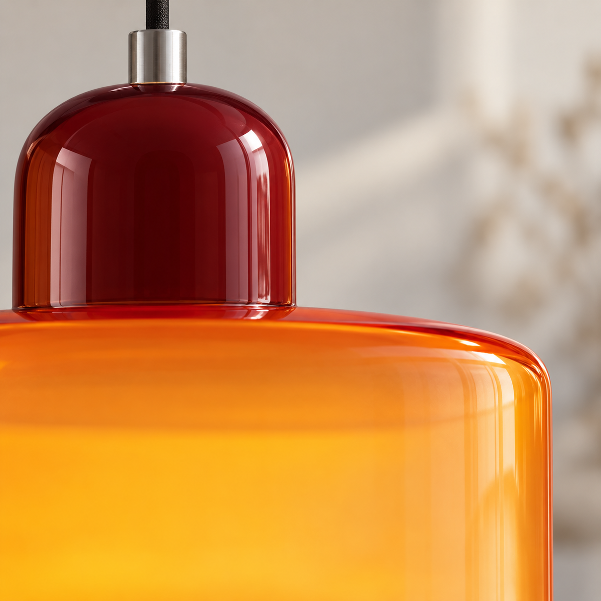Gros plan du verre ambré translucide et du capuchon bordeaux lisse de la suspension.