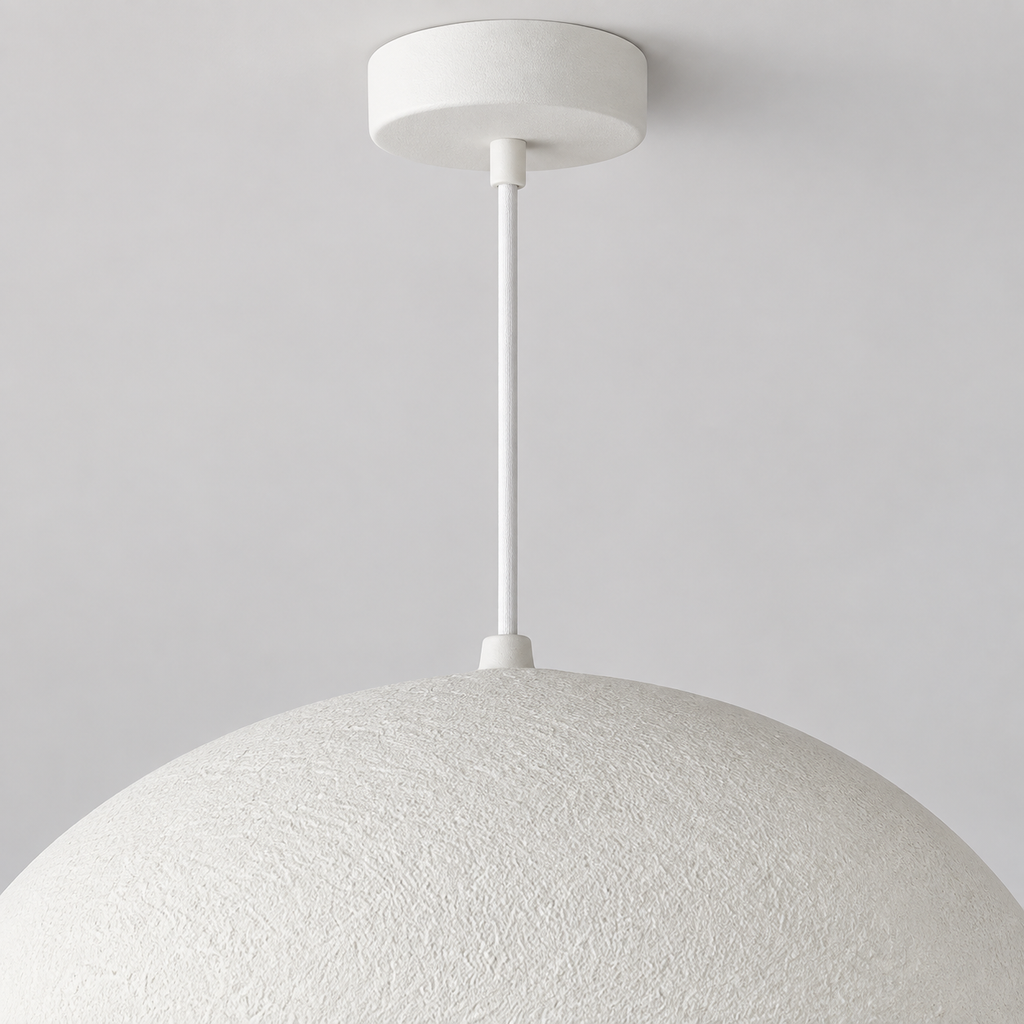 Détail supérieur de la suspension Nivora blanche, montrant le câble fin et le raccord au dôme sur fond clair.