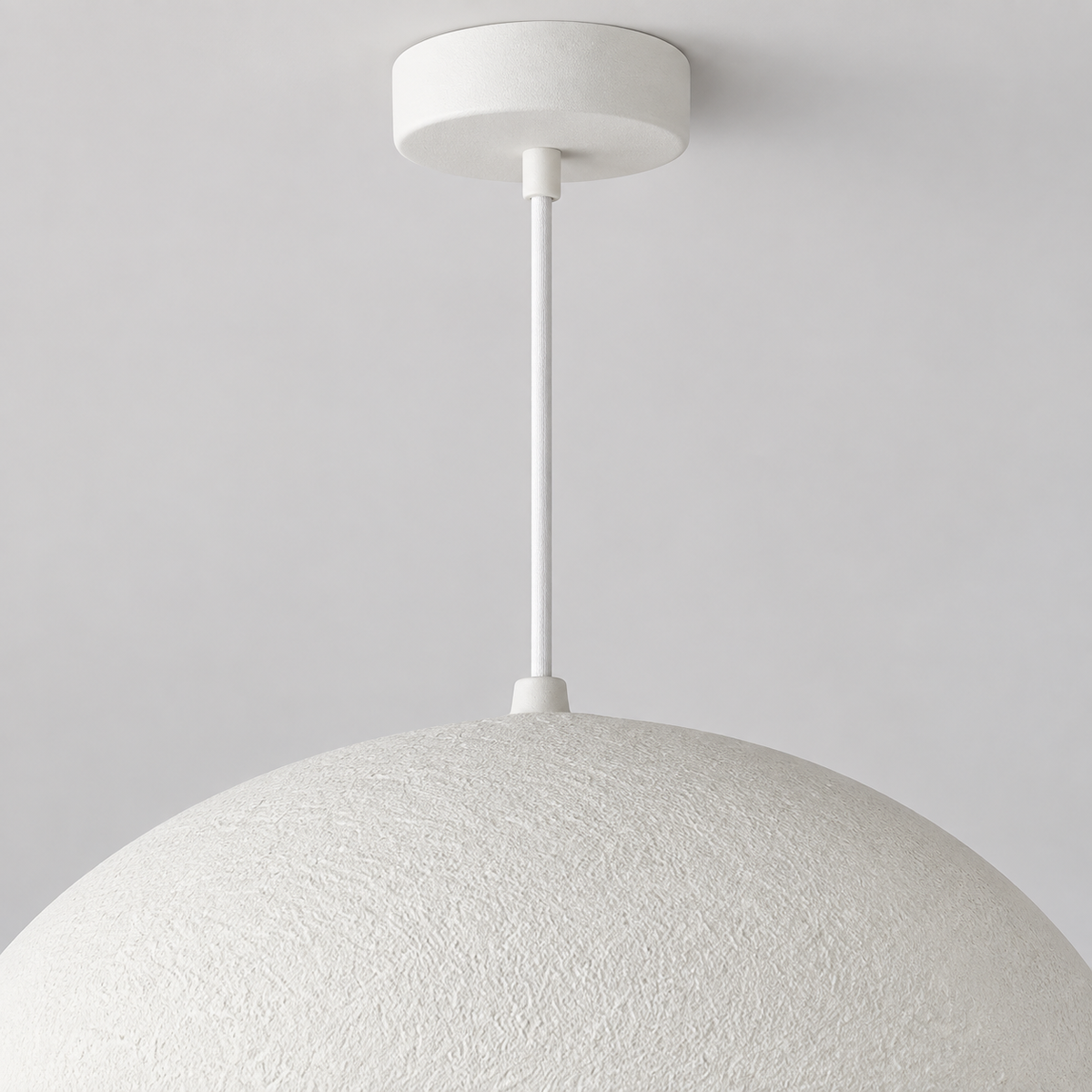 Détail supérieur de la suspension Nivora blanche, montrant le câble fin et le raccord au dôme sur fond clair.