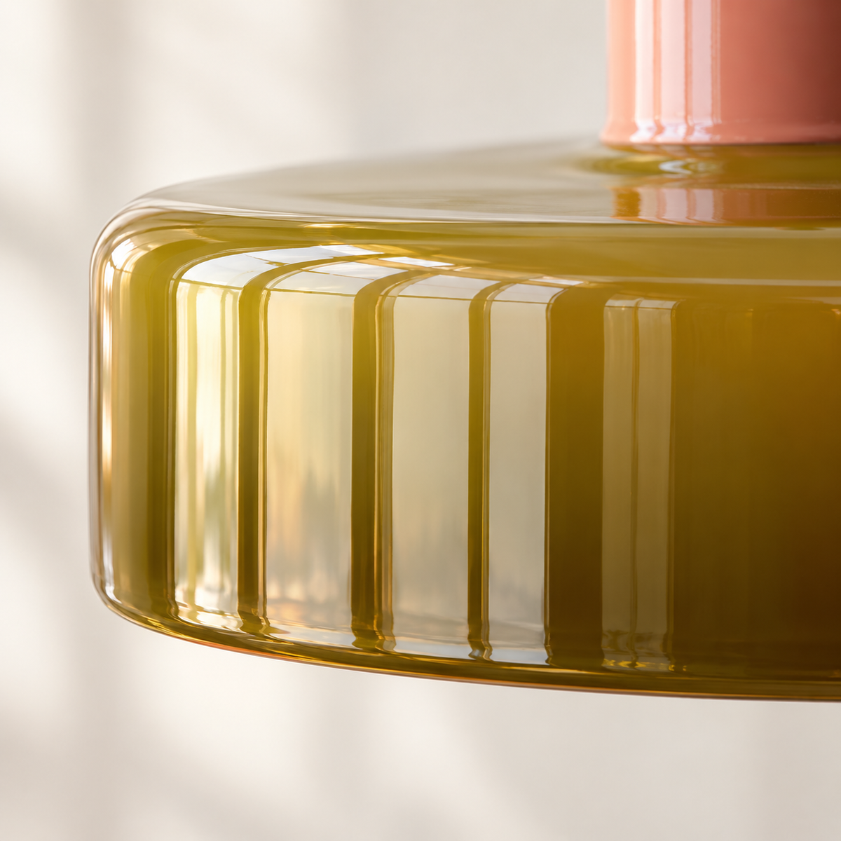 Gros plan du bord en verre teinté olive, brillant et nervuré verticalement, de la suspension Nolia.