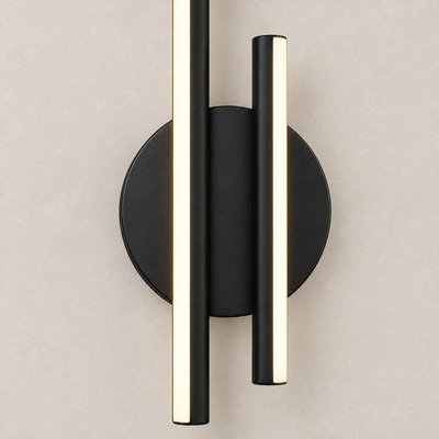 Détail technique de l’applique Sila : platine murale ronde noire et jonction des deux barres LED verticales sur enduit clair.